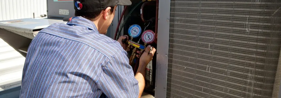 HVAC technician servicing a condenser unit in Wadsworth